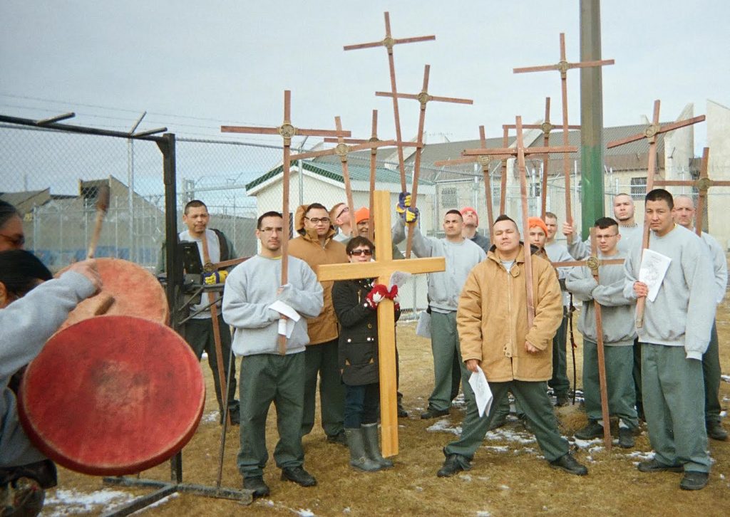 Restorative Justice – outdoor Way of the Cross Men gathered outdoors with wooden crosses and a drum