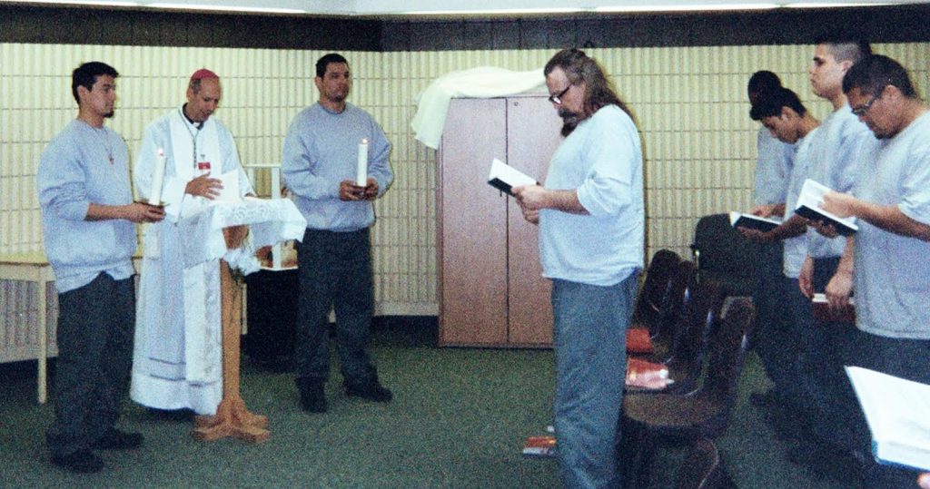 Restorative Justice – prayer service Priest leading a prayer service with a group of men