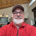 Smiling man in a red jacket and cap